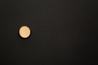 特写镜头中，一个金色的瓶盖置于黑色背景与复制空间
