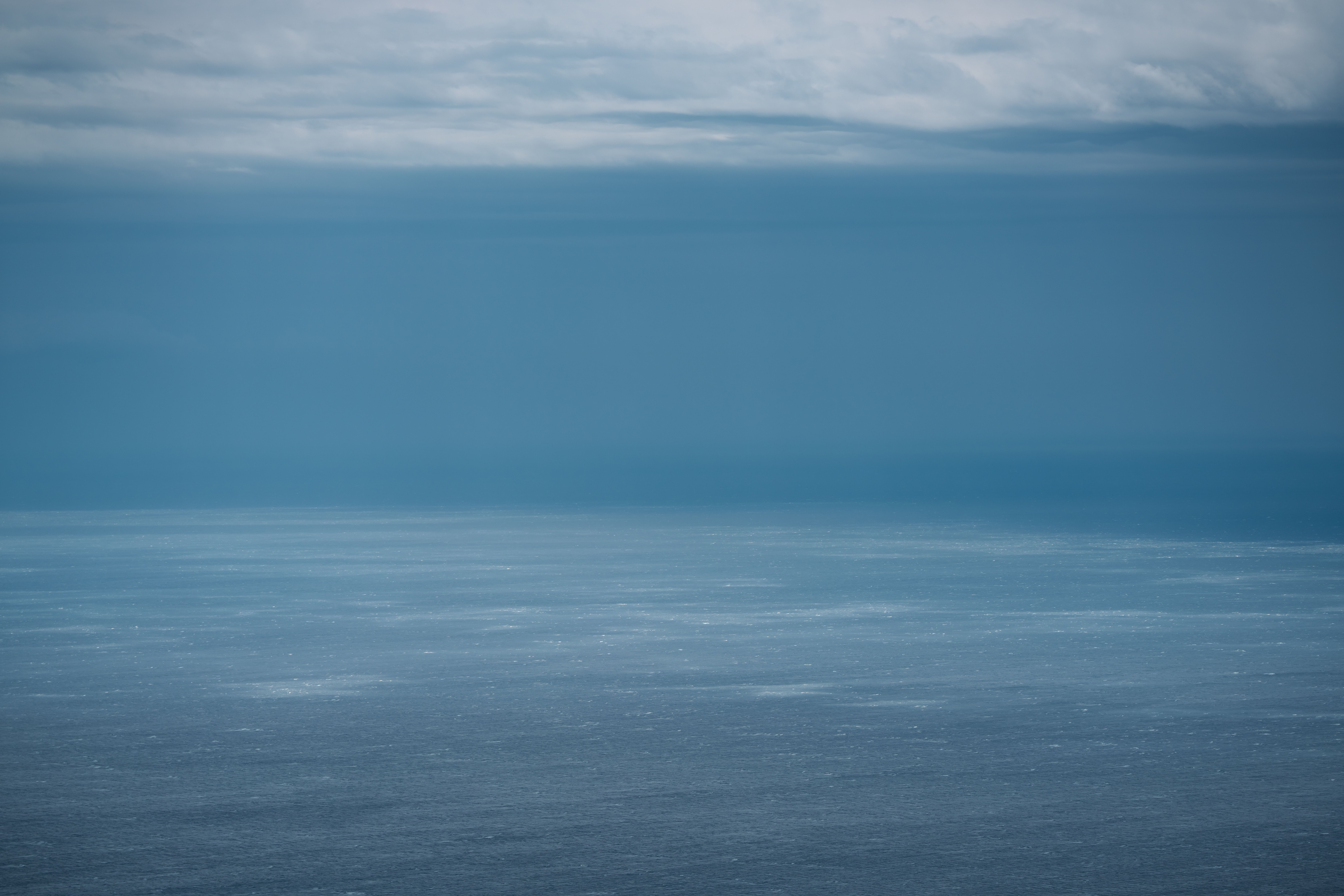 gratis Een sereen uitzicht op de oceaan met een uitgestrekte hemel, dat de rust en de weidsheid van de zee vastlegt. Stockfoto