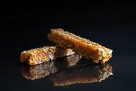 Delicious nut brittle placed on black surface