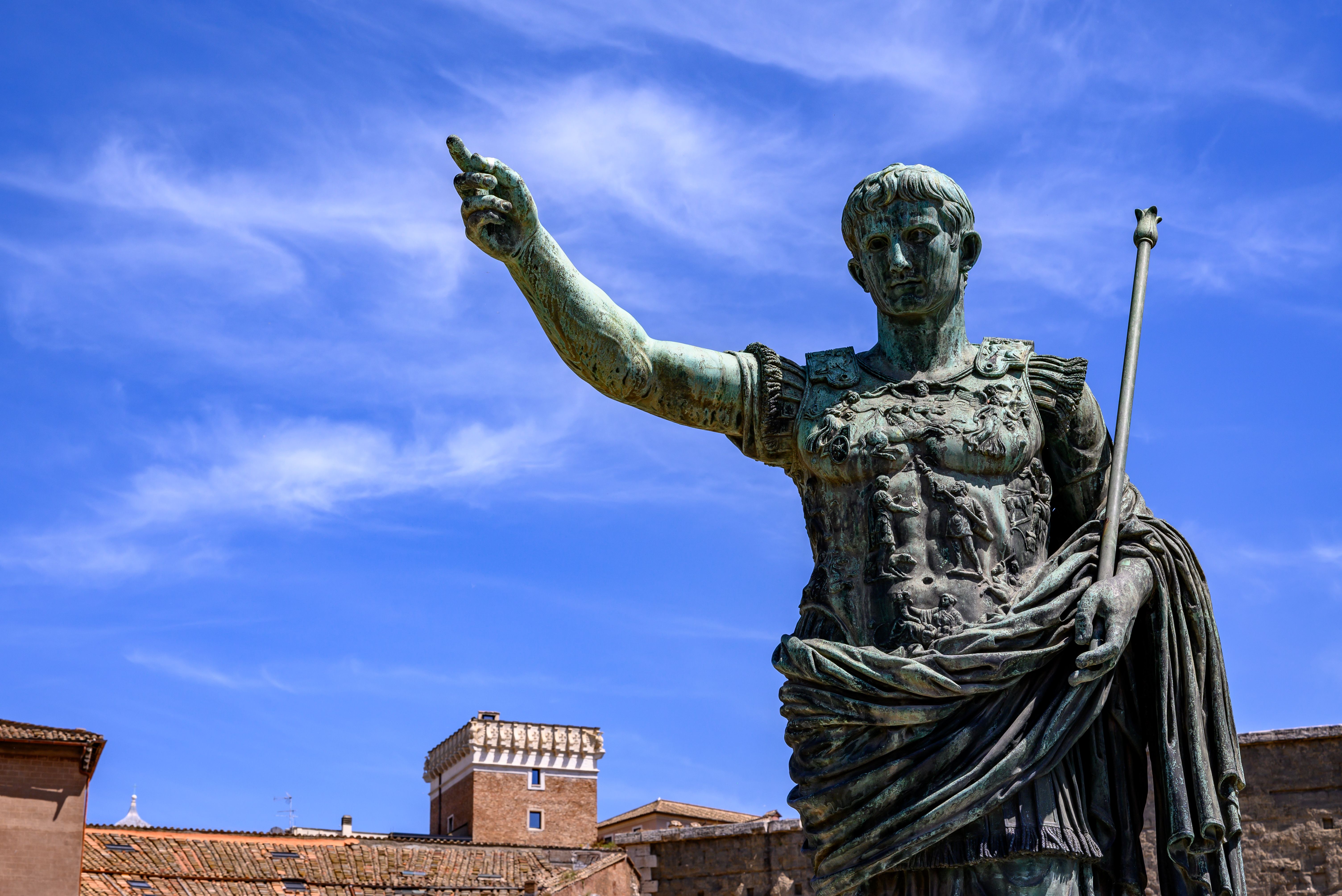 Majestic bronze statue of Julius Caesar in Rome, Italy, with historic architecture backdrop.
