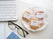 Eyeglasses with snack near keyboard on white surface
