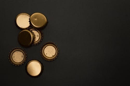 Metallic Gold Bottle Caps On Black Background