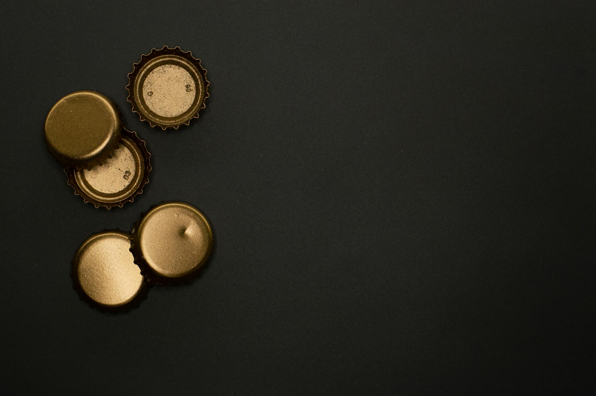 Metallic Bottle Caps On Black Background