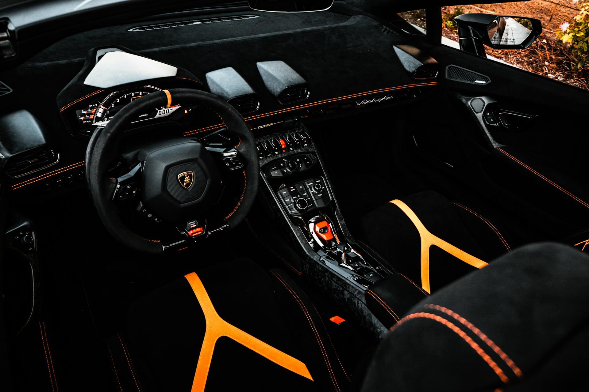 Explore the sleek and luxurious interior of a modern sports car with bold orange accents and high-end features.