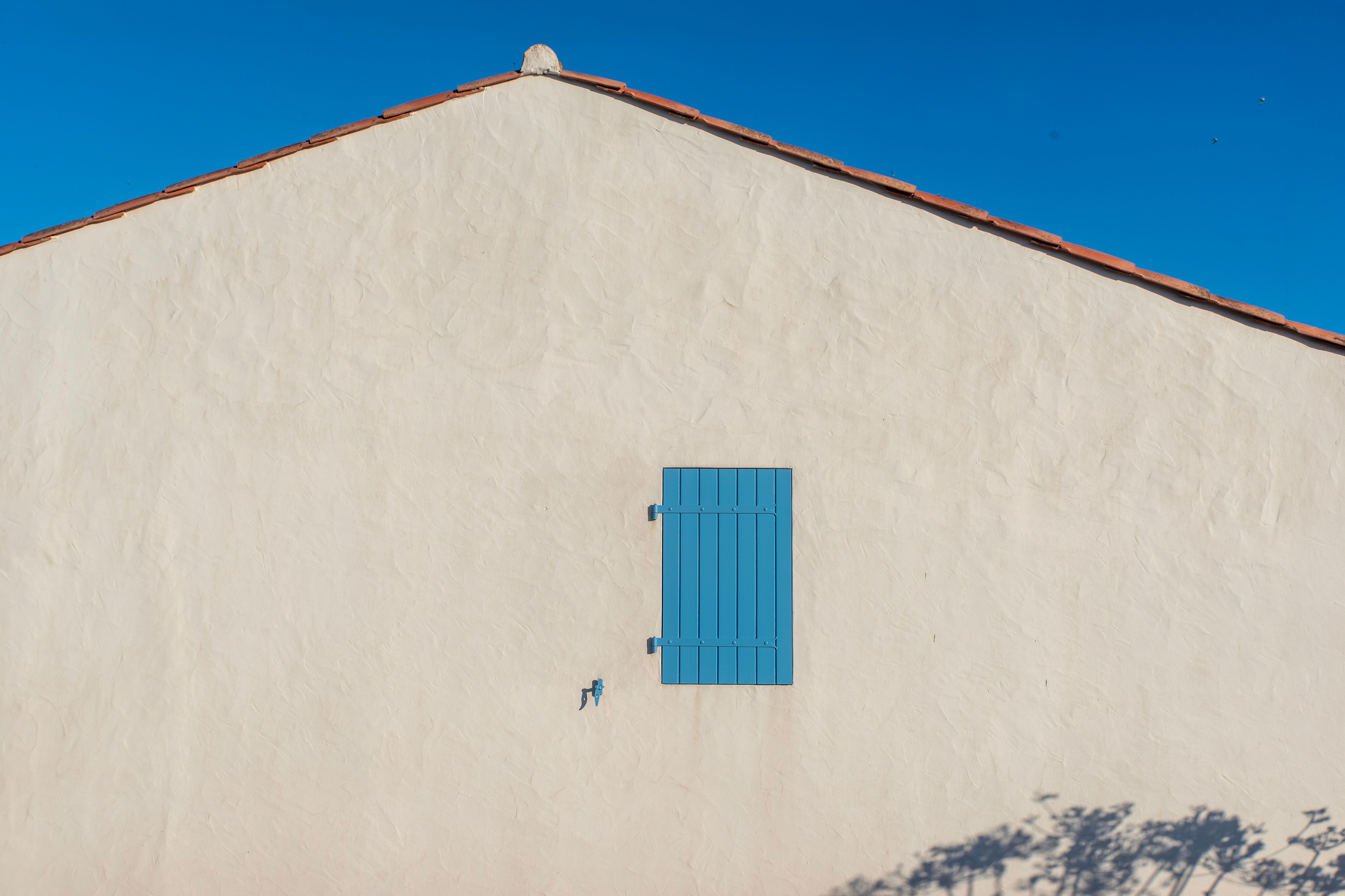 stucco home exterior mid soft-wash, low-pressure application, clean vs dirty contrast, bright sky