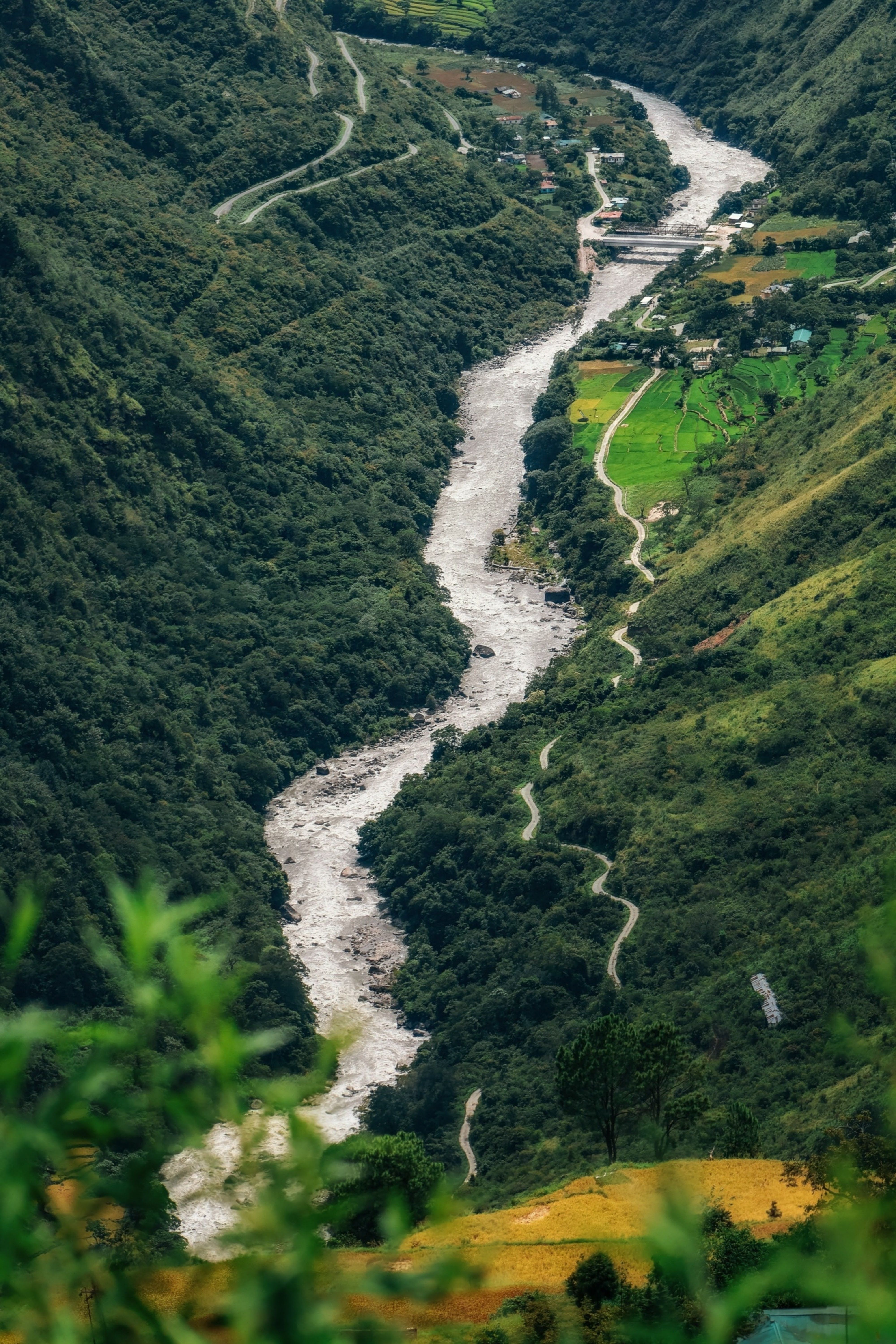 A stunning river winding through lush green valleys and mountains, captured from above.