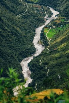 A stunning river winding through lush green valleys and mountains, captured from above.