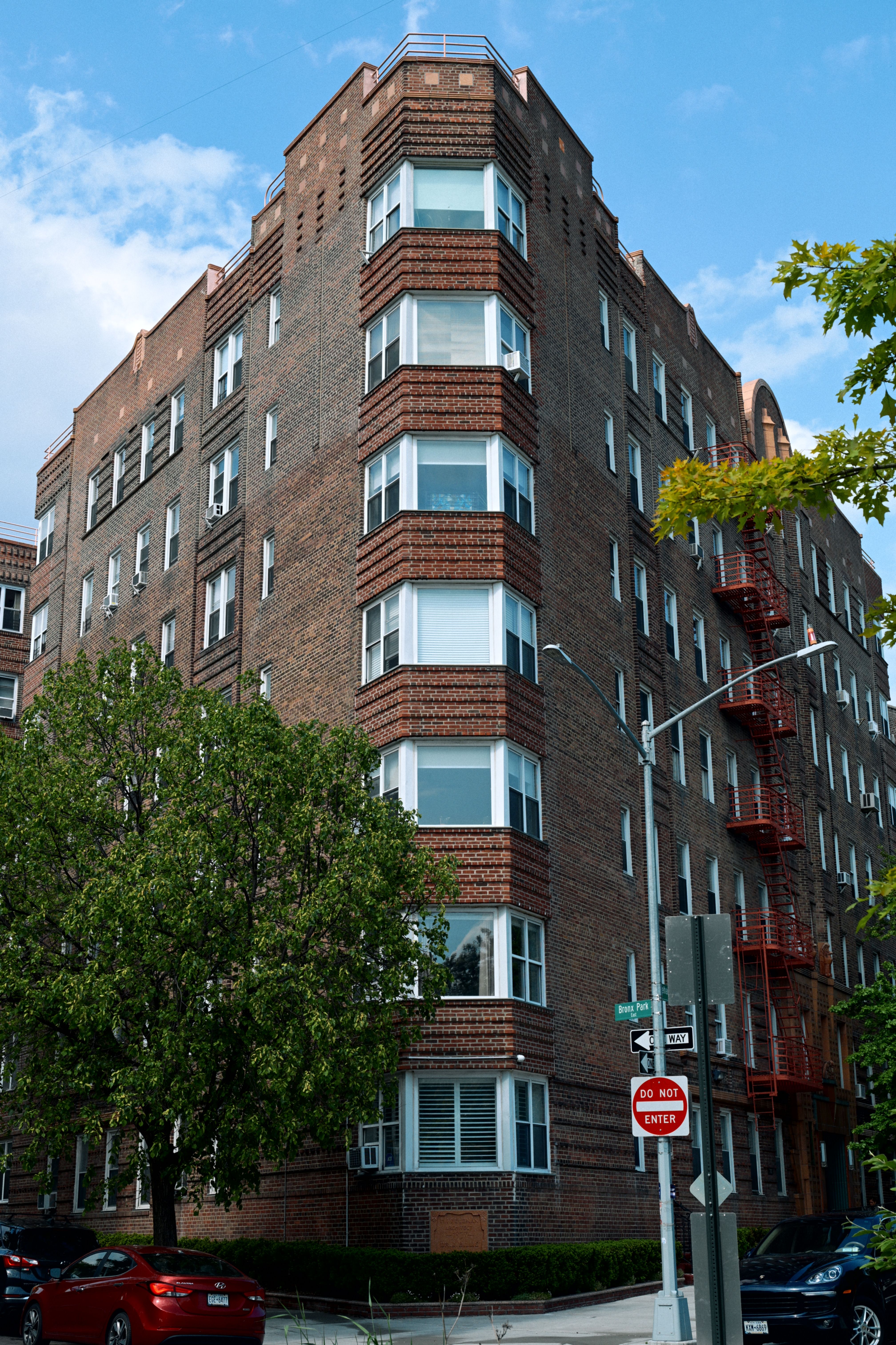 City apartment complex with prominent red brick facade and fire escape.