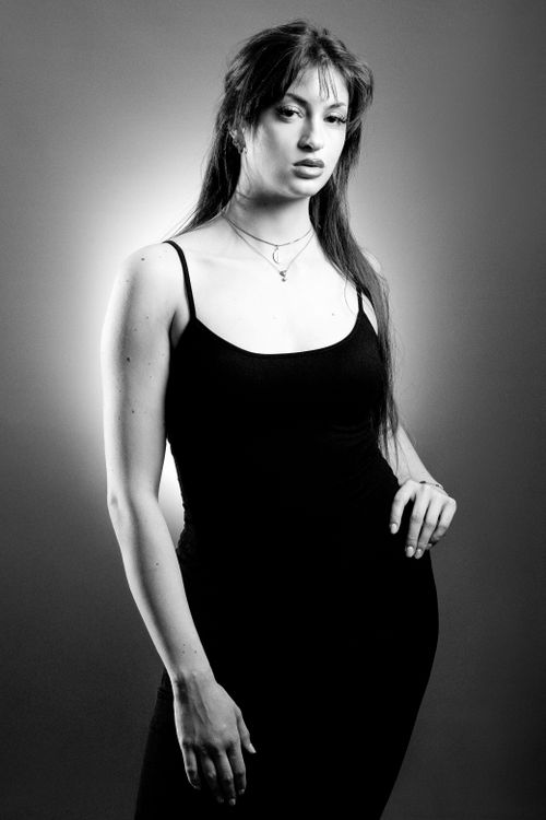 Free Black and white portrait of a woman in a dress, exuding elegance and confidence. Stock Photo
