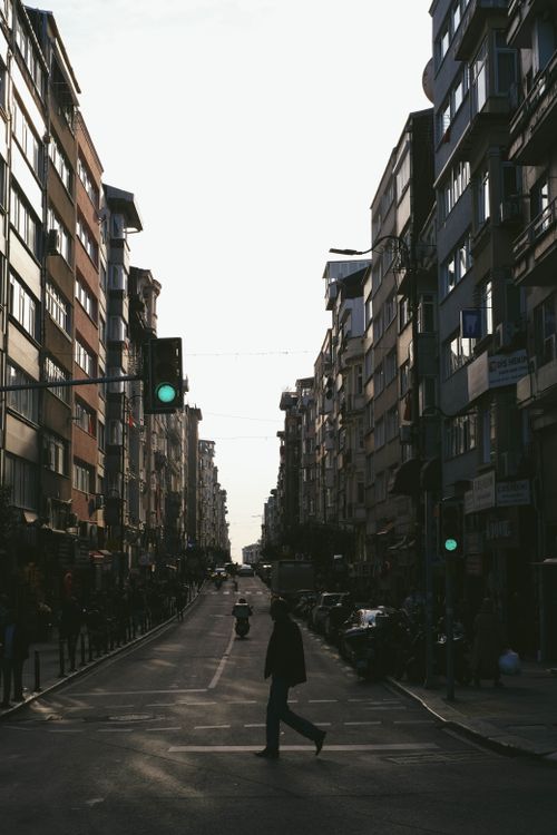 Free Silhouette of a person crossing a street flanked by tall buildings in İstanbul. Stock Photo