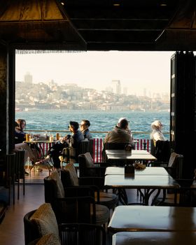 Relaxing at a café overlooking the Bosphorus with a stunning view of Istanbul's skyline.