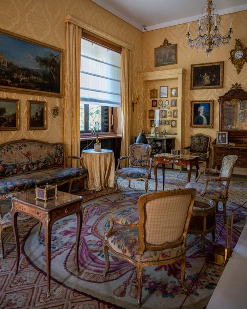 Free Luxurious vintage living room in Milan featuring ornate furniture, art, and a chandelier. Stock Photo
