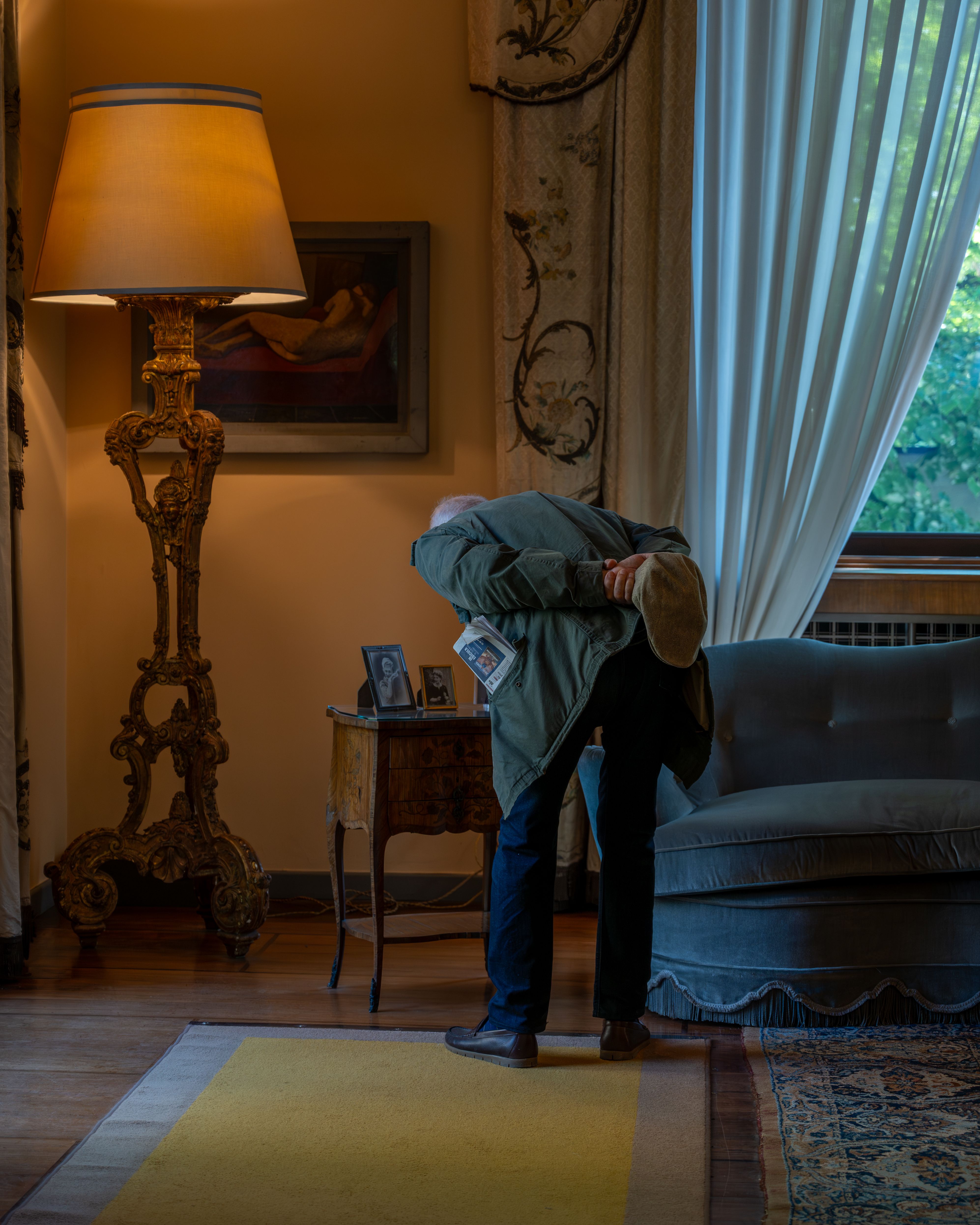 Elegant interior of Milano home with a person admiring art. Warm and sophisticated ambiance.
