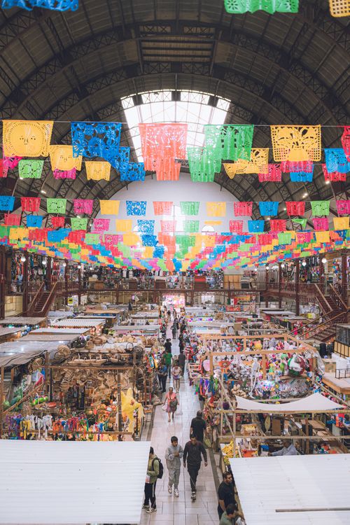 Free Colorful papel picado decorates Mercado Hidalgo in Guanajuato, Mexico, bustling with shoppers. Stock Photo
