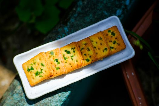 Savoury Vietnamese herb crackers on a white porcelain plate in Hue, Vietnam.