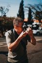 Focused man taking photo on camera on street in daytime