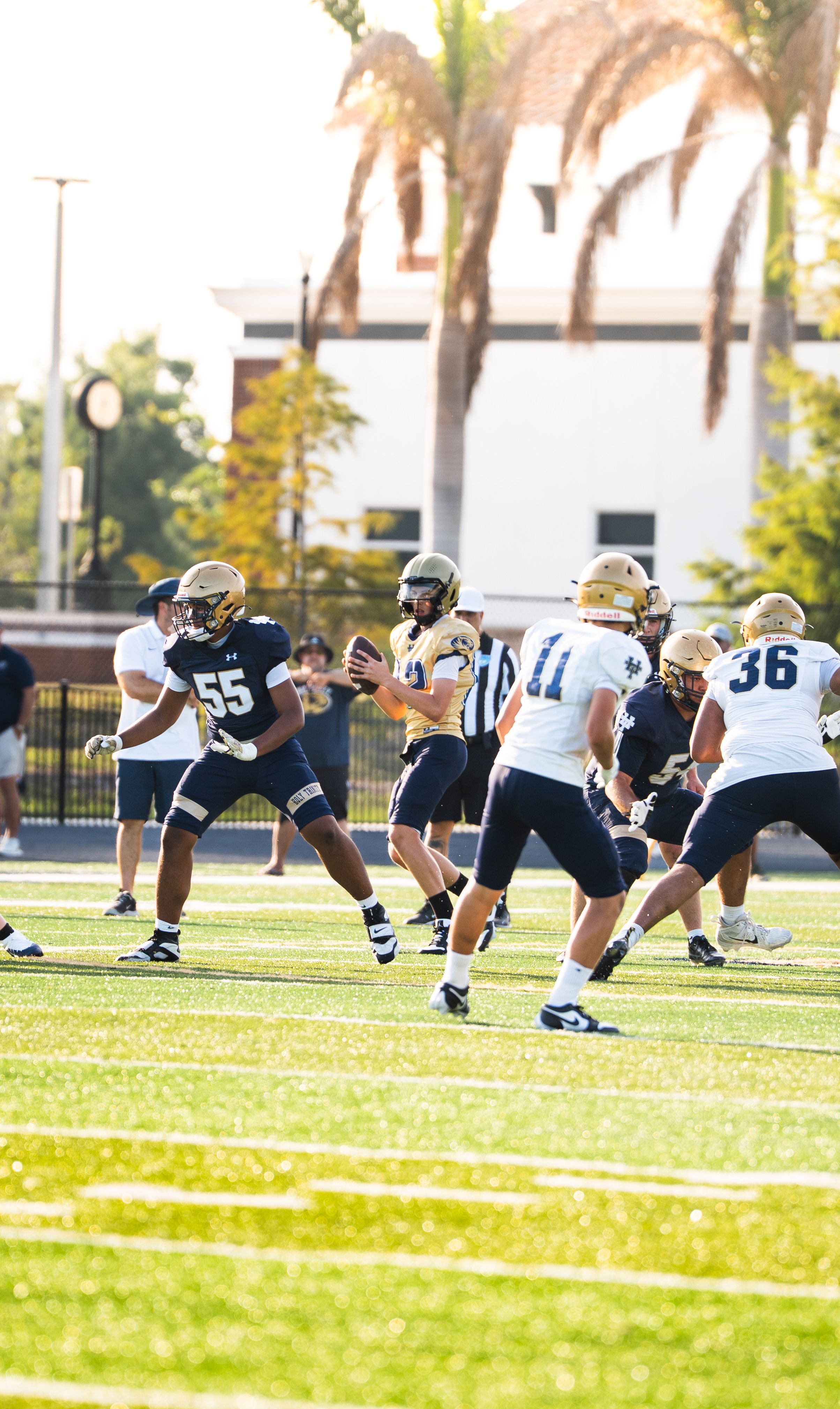 A thrilling moment in a high school American football game with players strategizing on the field.