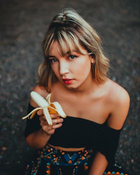 一位圣保罗年轻女子手持去皮香蕉，摆出时尚而沉思的姿势