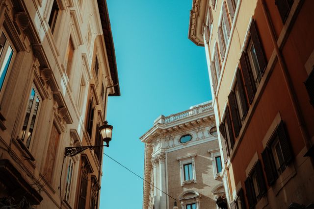 Idyllic European street view between historical buildings with clear blue sky.