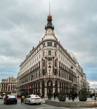 Captivating view of Edificio Metrópolis in Madrid, Spain, showcasing stunning architecture on a busy street.