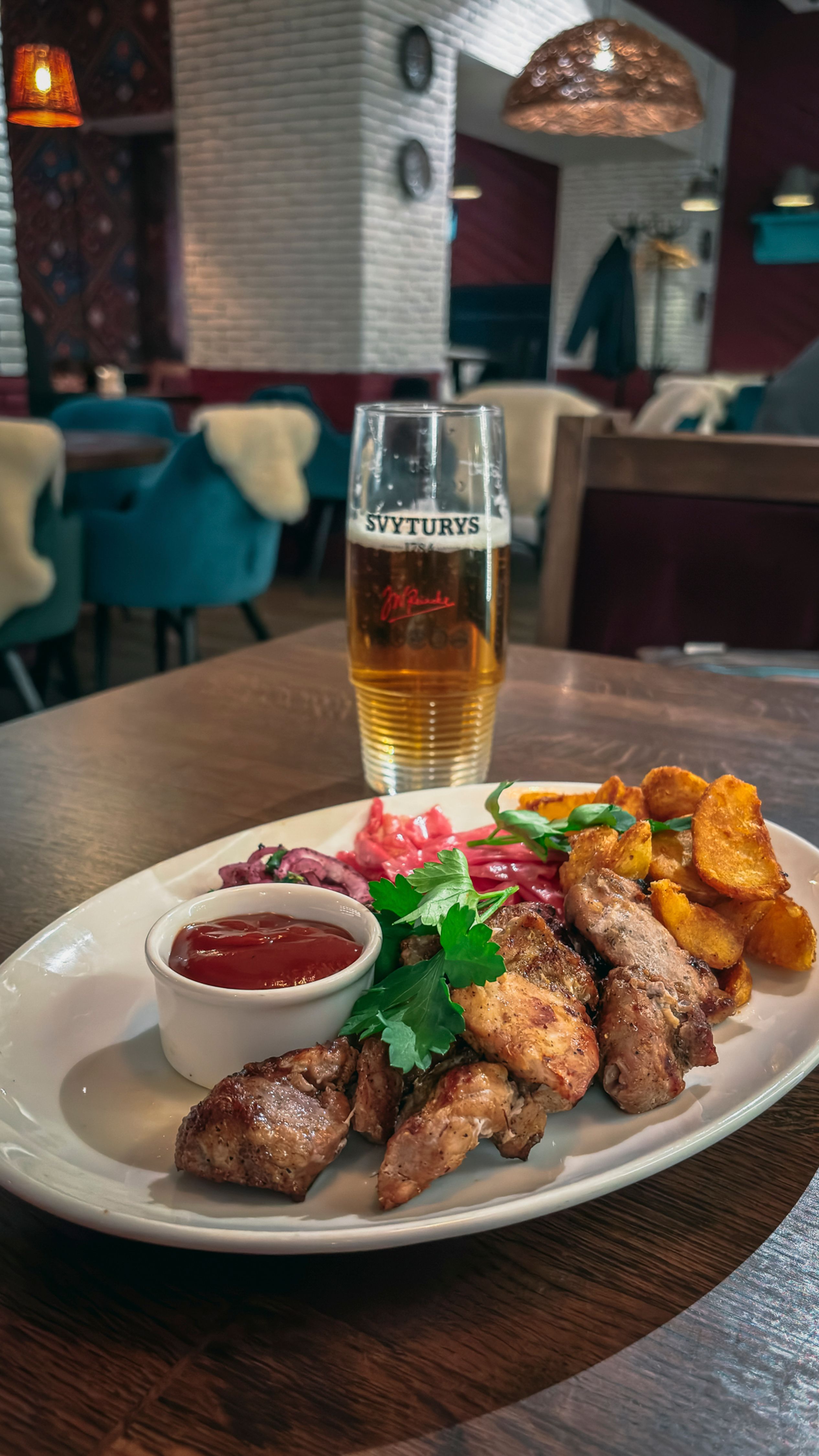 Enjoy a traditional Lithuanian meal paired with a local beer in a cozy Vilnius restaurant setting.