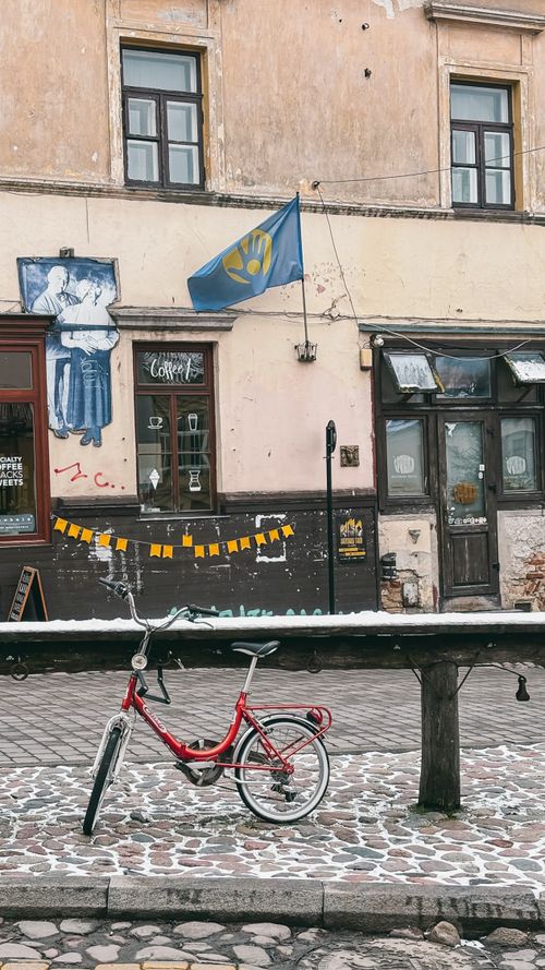 Free Explore the historic streets of Vilnius with a vintage red bicycle and cultural elements. Stock Photo