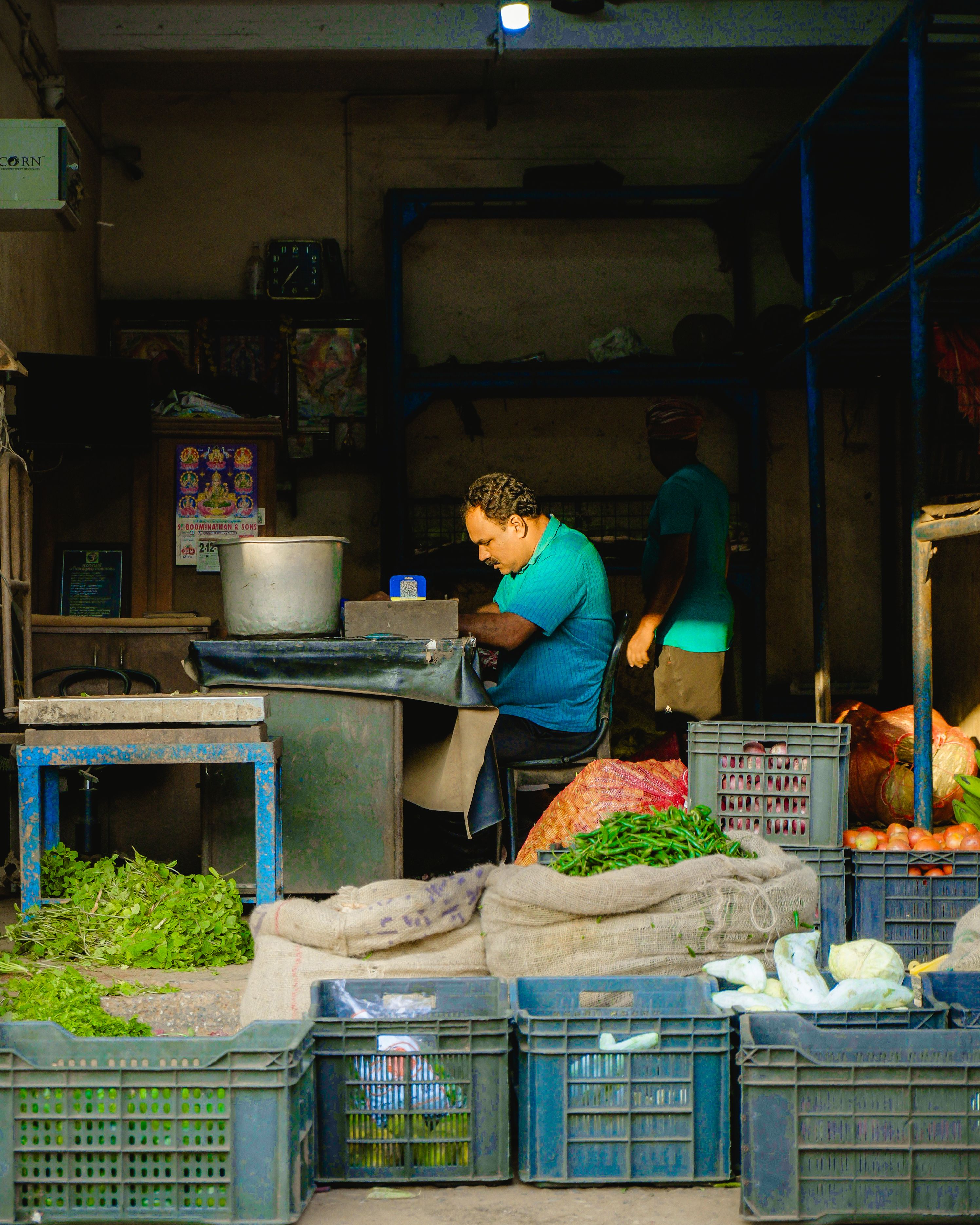 Market vendor at a local stall in Thiruvananthapuram with various fresh produce on display.