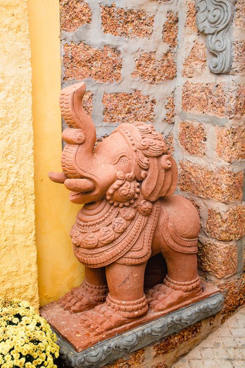 Free Decorative terracotta elephant statue against rustic stone wall. Intricate design adds cultural charm. Stock Photo