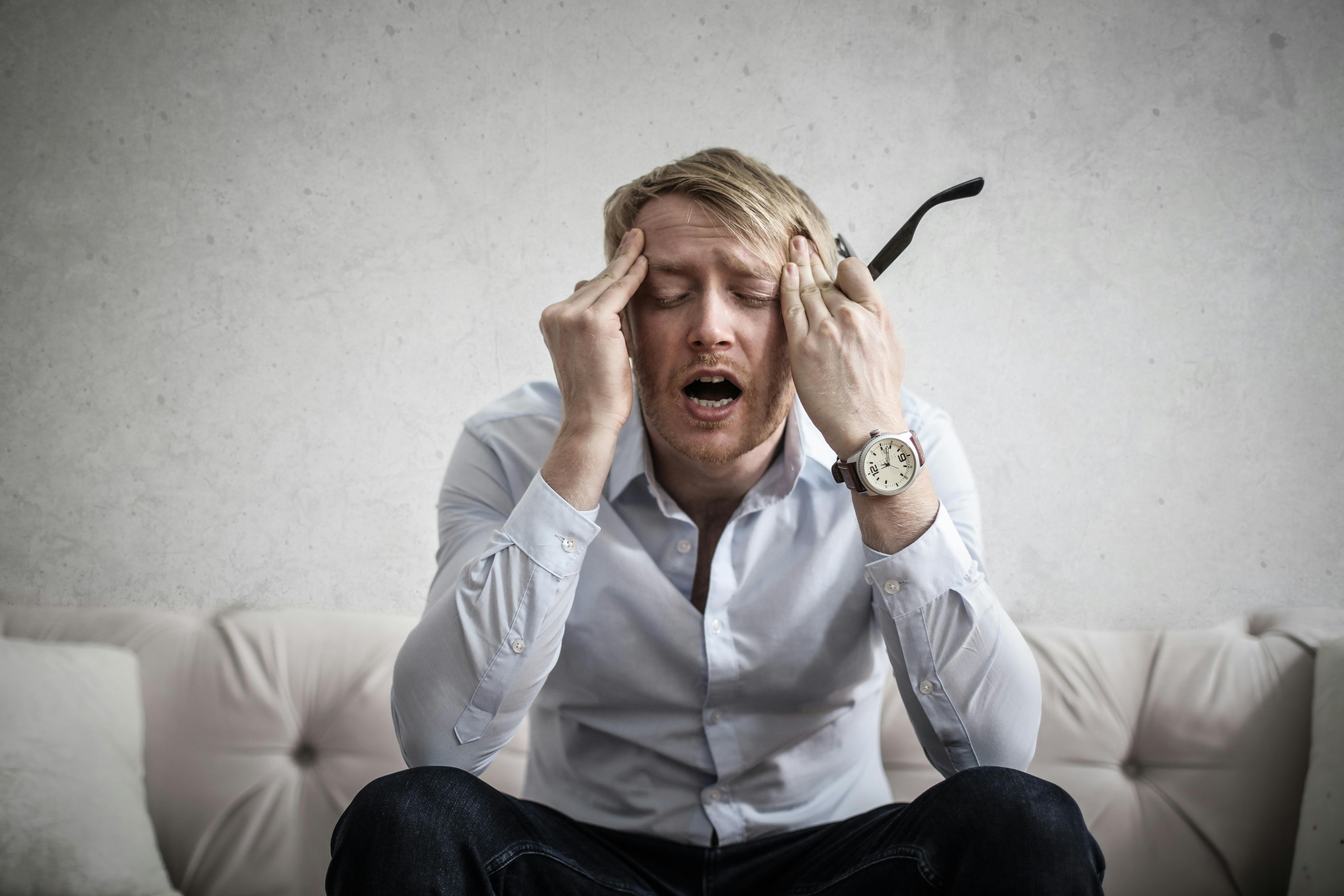 A man touches his head. | Photo: Pexels