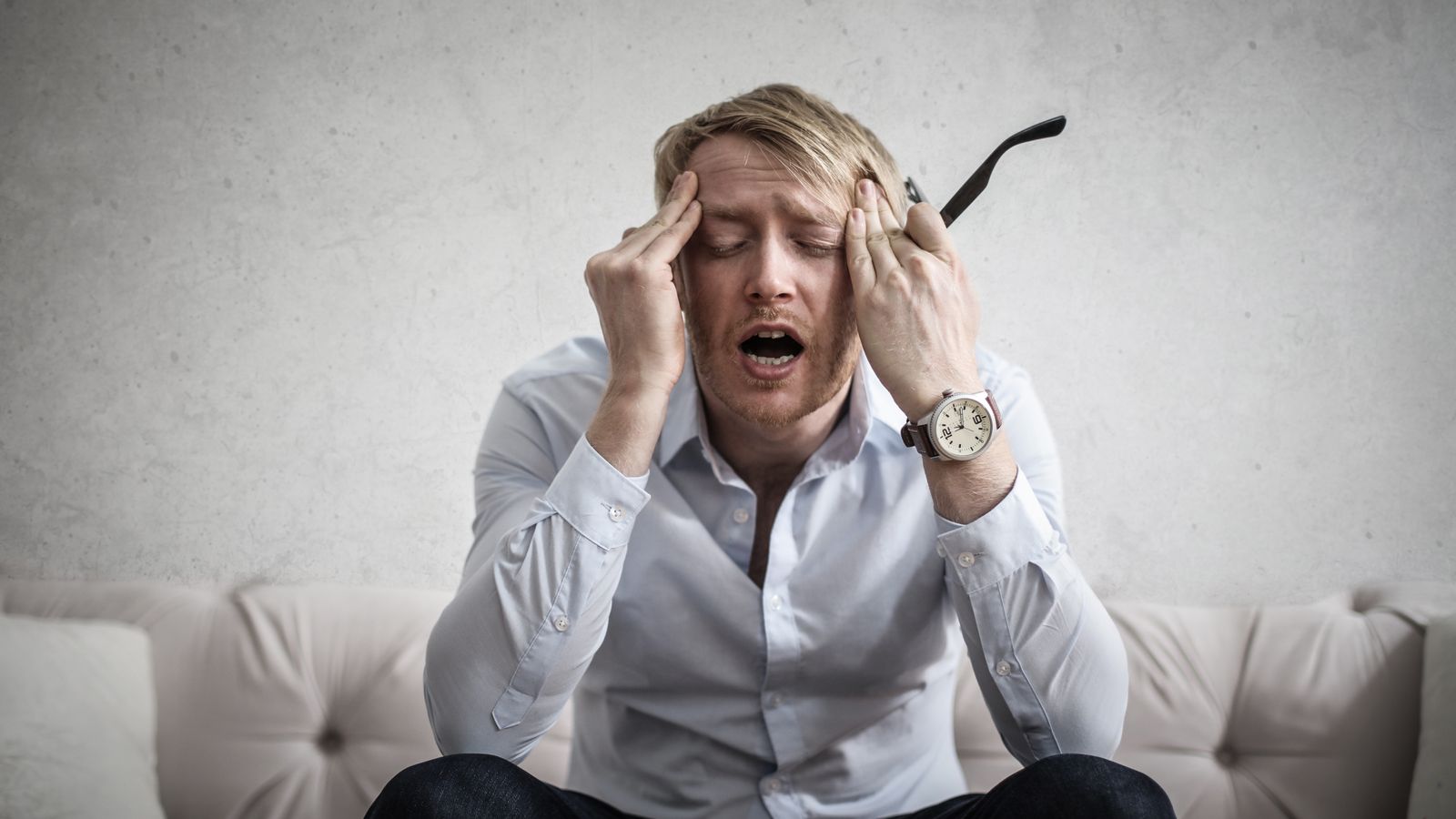 A man sitting stressed at home