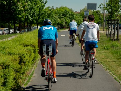 Group of cyclists riding on a sunny day in Wrocław, Poland, showcasing outdoor activity and fitness.