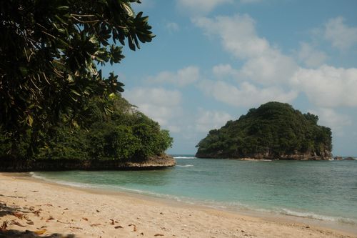 Free Serene beach with lush islands in Jawa Timur, Indonesia under a blue sky. Stock Photo