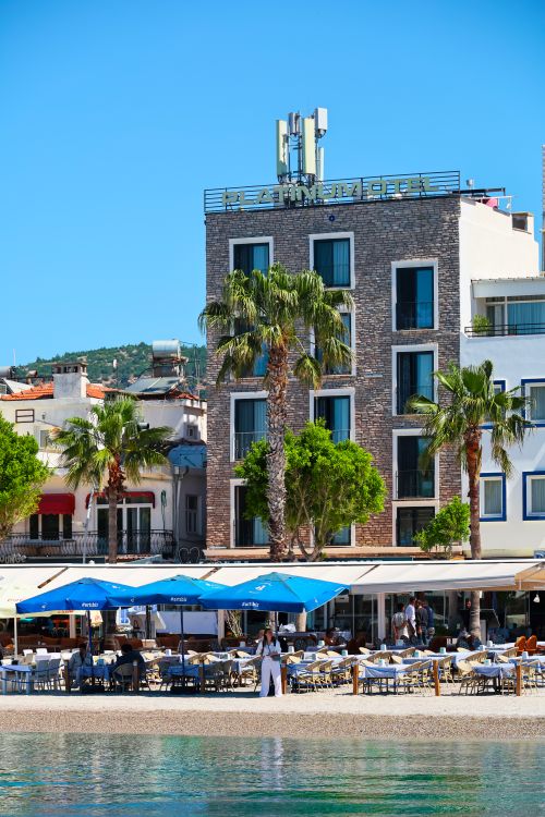 Free Sunny beachfront scene with cafe and modern hotel in Bodrum, Türkiye. Stock Photo