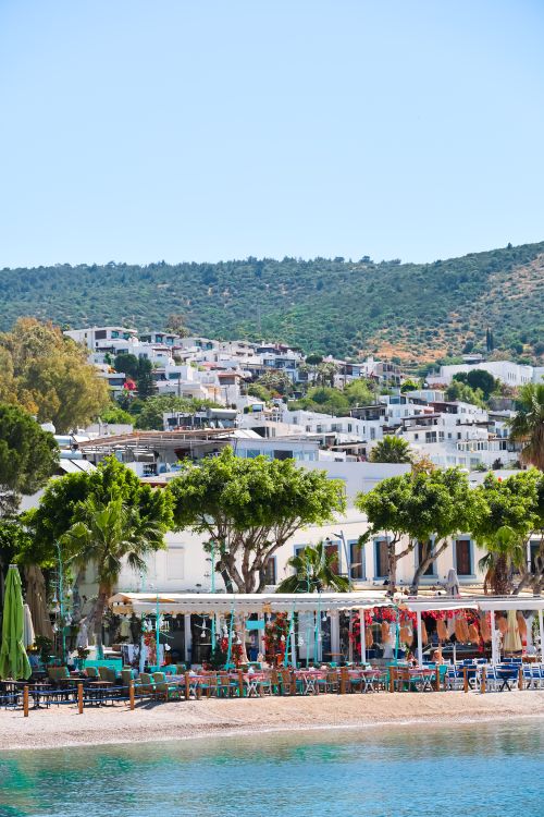 Free Stunning view of Bodrum's waterfront with traditional whitewashed homes and lush greenery under a clear blue sky. Stock Photo
