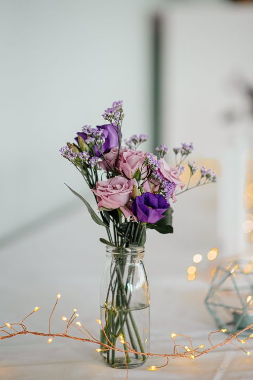 Free Beautiful bouquet of purple and pink flowers in a glass vase, perfect for weddings. Stock Photo