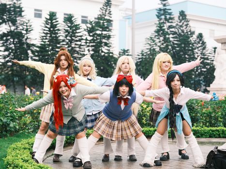 Group of adults in cosplay costumes posing outdoors with colorful attire in Việt Nam.