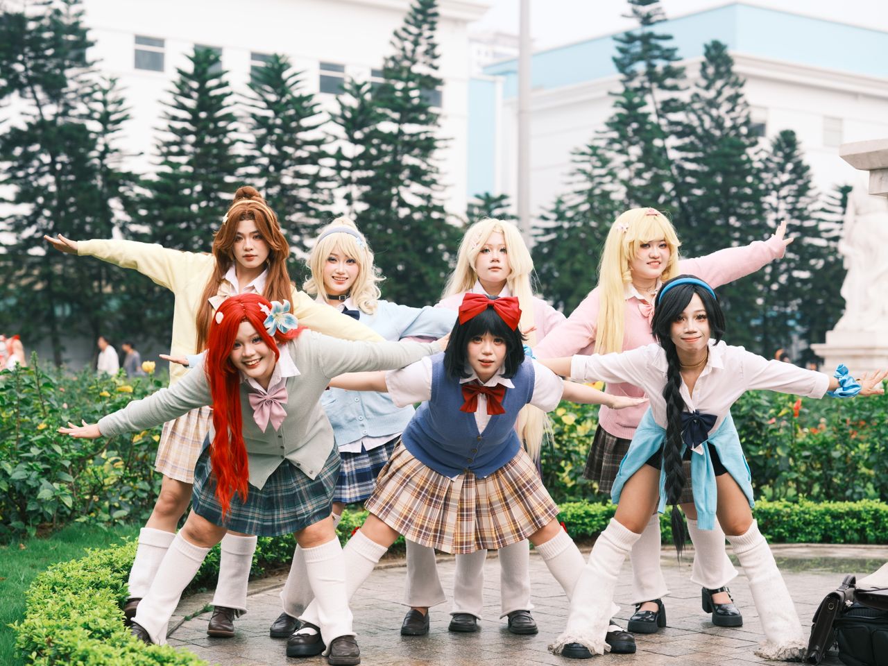 group of adults in cosplay costumes posing outdoors with colorful atti