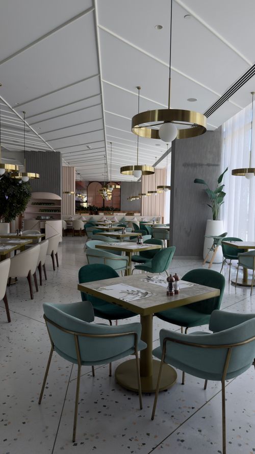 Free Chic restaurant with modern decor, featuring teal chairs and gold accents, ideal for dining. Stock Photo