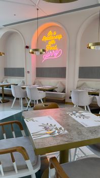 Chic cafe interior with neon sign and elegant seating. Perfect for a cozy dining experience.