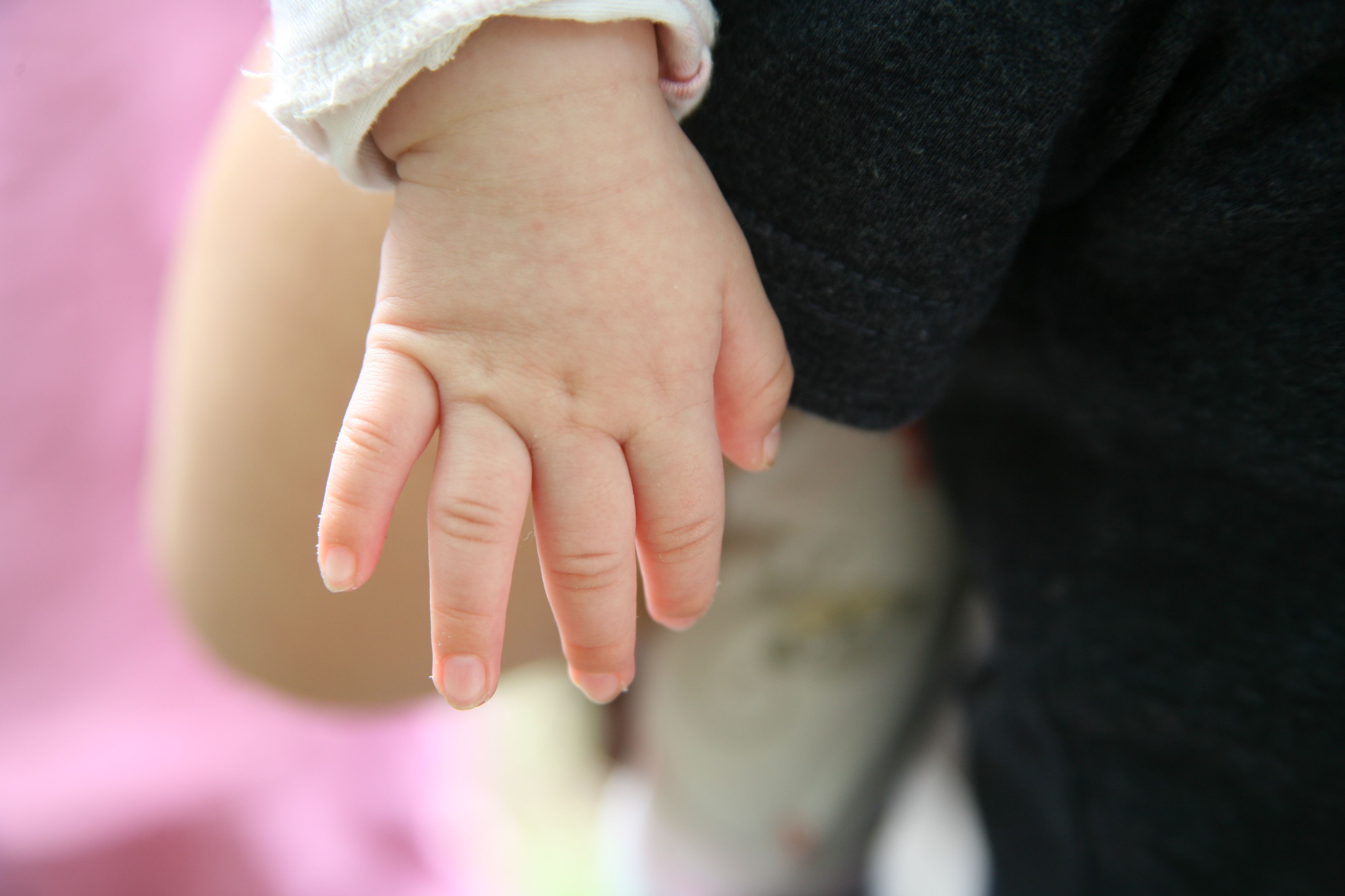 Detailed close-up of a baby's hand in soft natural light, showcasing delicate skin texture.