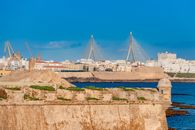 Beautiful view of Cádiz, Spain featuring historic architecture and Puente de la Constitución bridge over the bay.