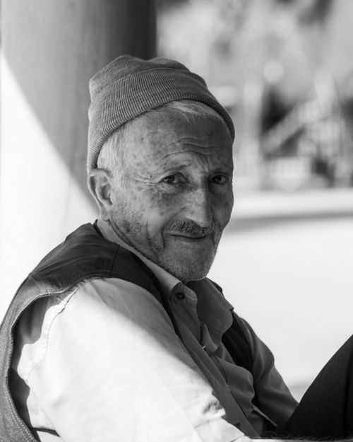 Free Black and white portrait of an elderly man in a beanie, showcasing a warm smile. Stock Photo