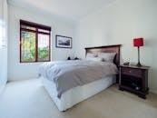 这间卧室时尚舒适，设有一张木床，床上配有红灯，旁边还有一扇大窗户