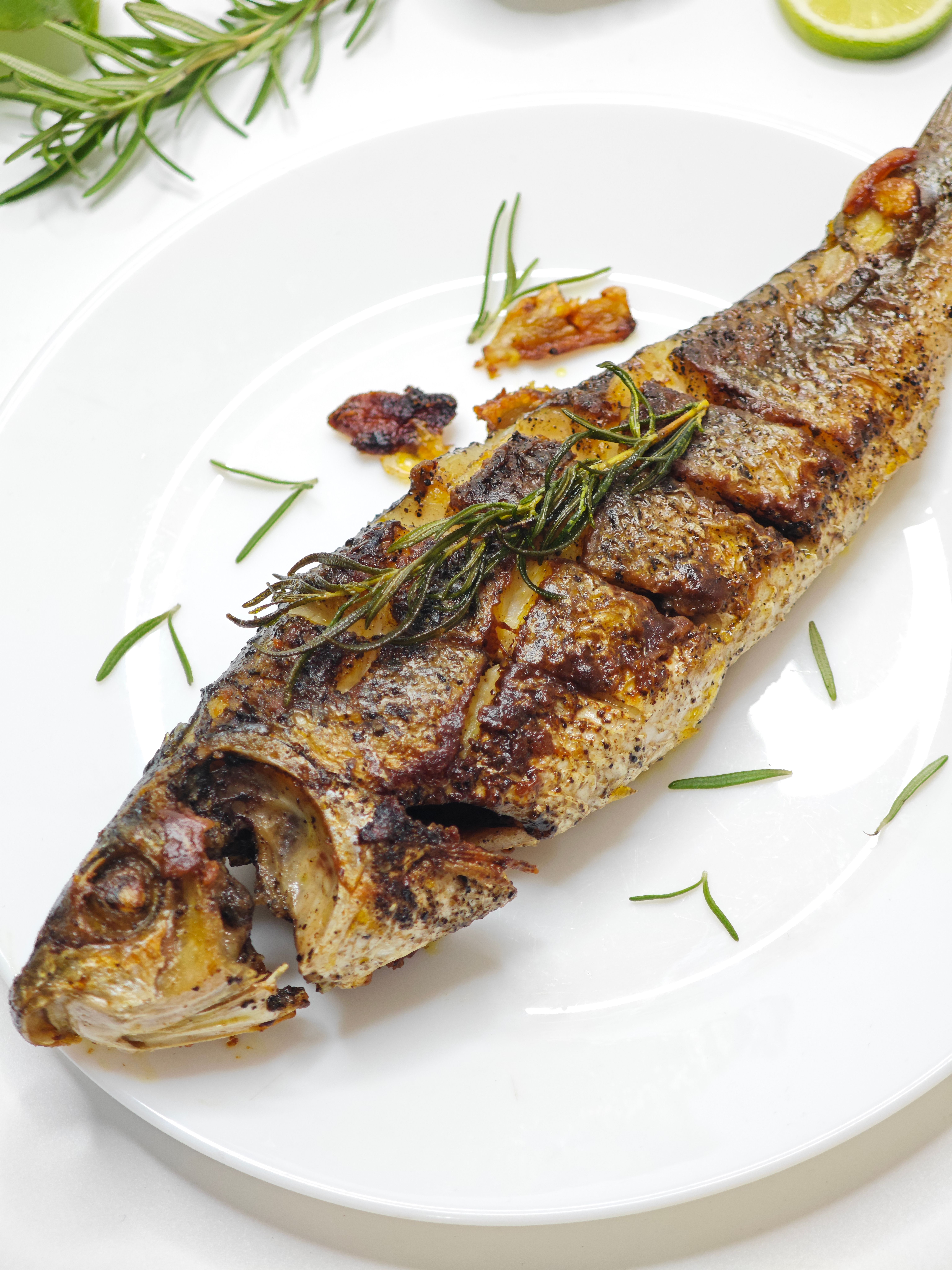 Delicious grilled whole fish garnished with fresh herbs, perfect for culinary presentations.