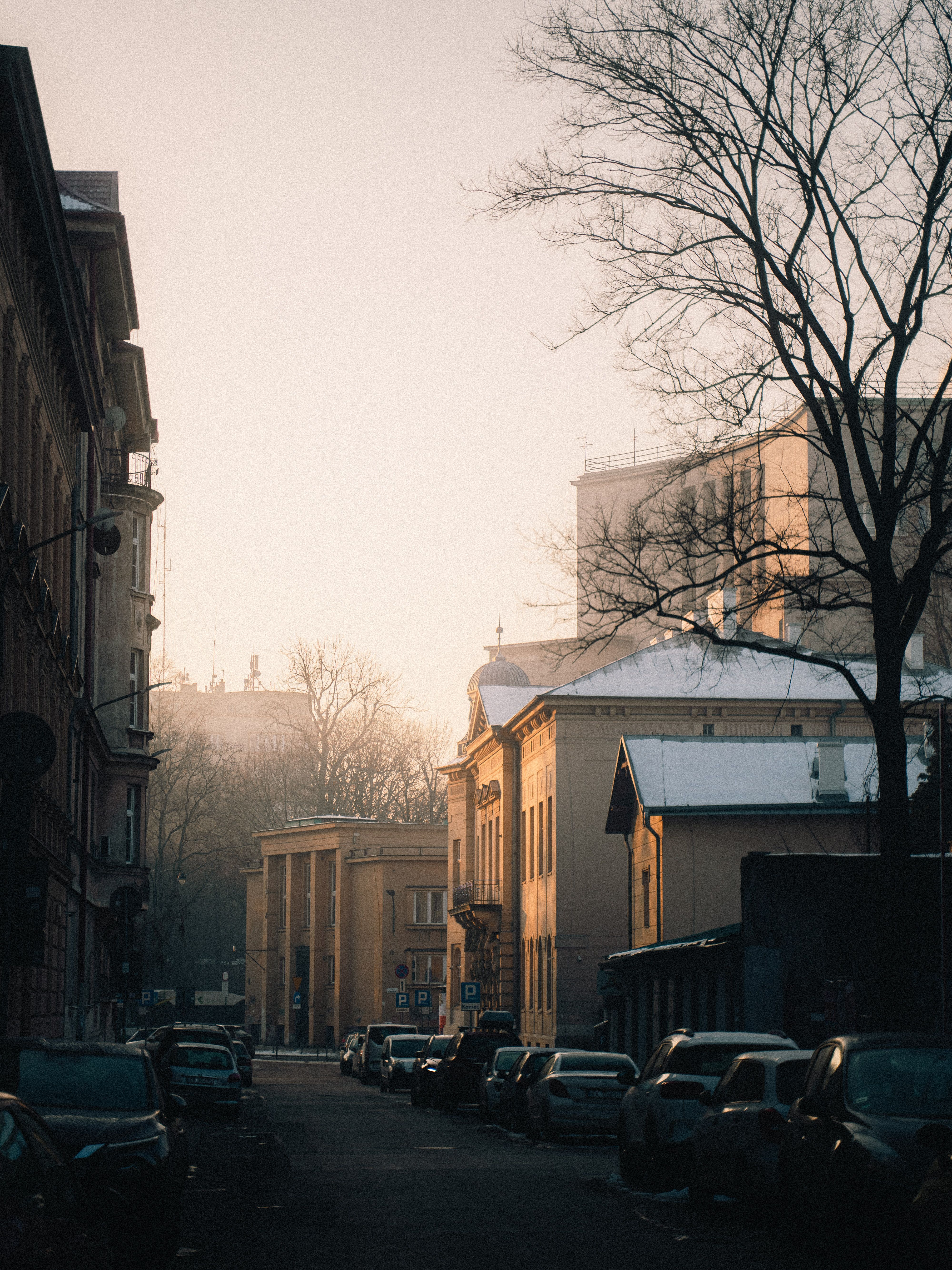 Serene winter morning in Kraków with snow-covered rooftops and a warm glow.