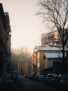 Serene winter morning in Kraków with snow-covered rooftops and a warm glow.
