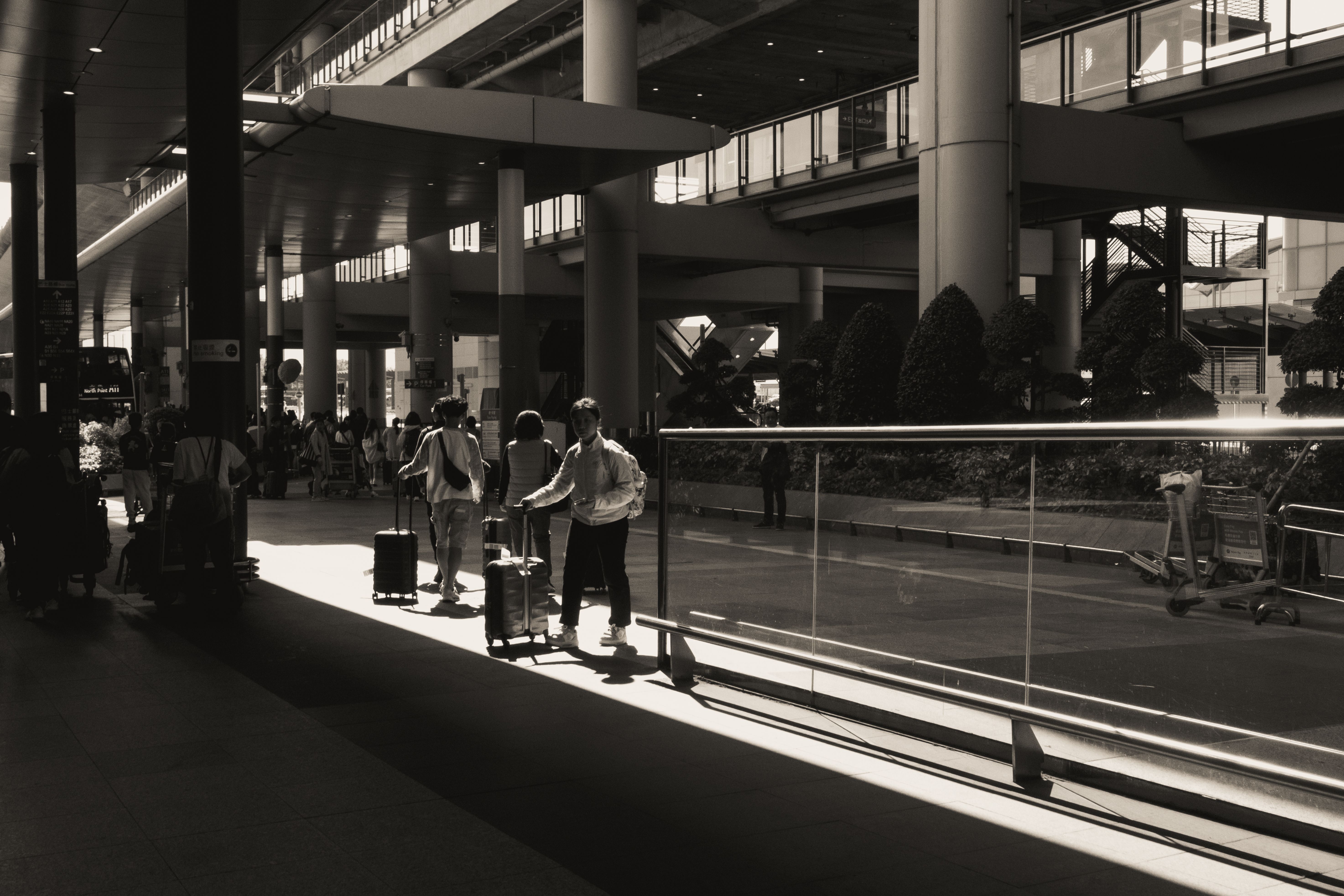 Travelers with luggage walking through a modern airport terminal