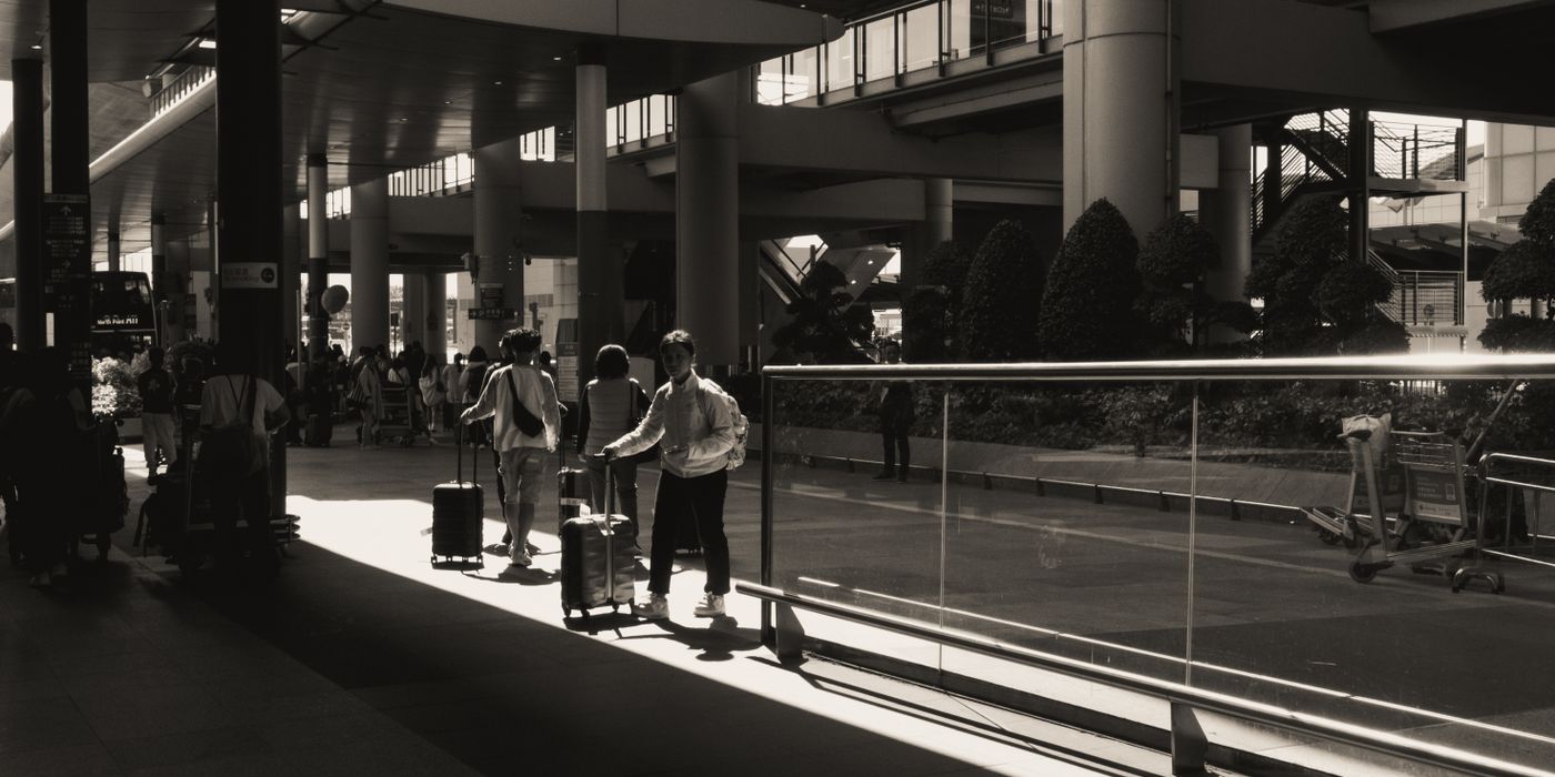 Travelers with luggage walking through a modern airport terminal
