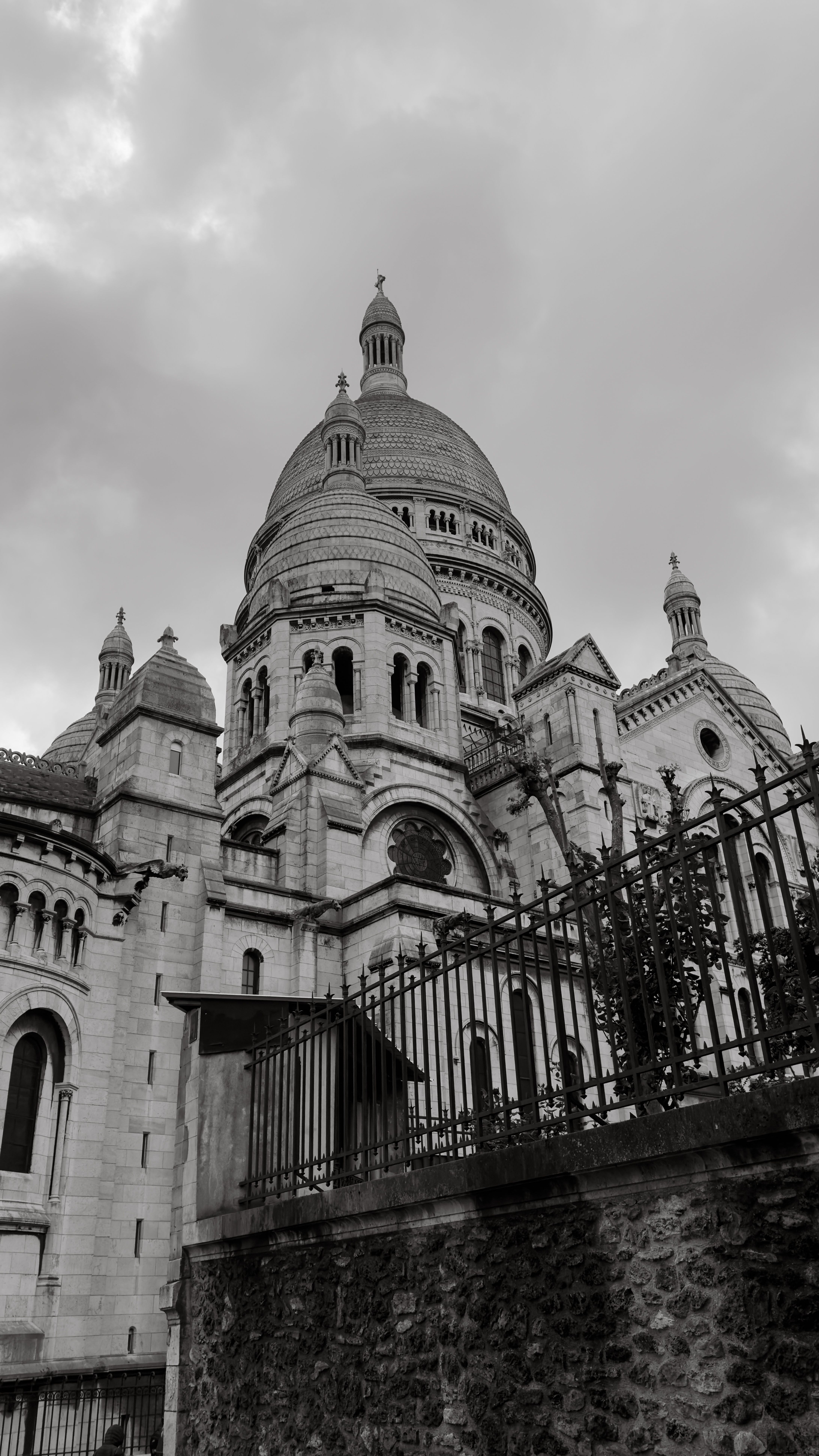 A dramatic black and white photo of the Sacré-Cœur Basilica in Paris, showcasing architectural details.
