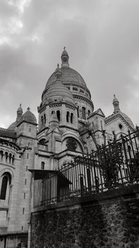 A dramatic black and white photo of the Sacré-Cœur Basilica in Paris, showcasing architectural details.